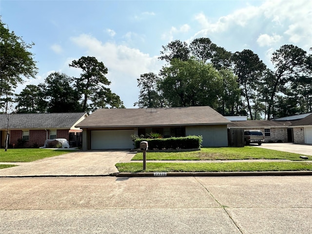 single story home featuring a garage, concrete driveway, and a front lawn