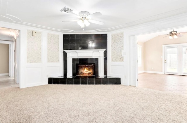 unfurnished living room featuring carpet flooring, visible vents, and a decorative wall