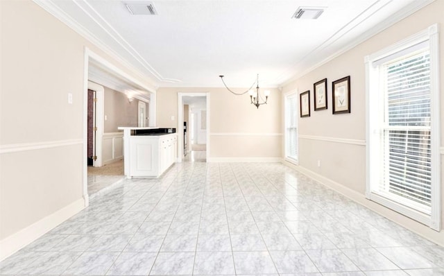 spare room with visible vents, a chandelier, baseboards, and ornamental molding