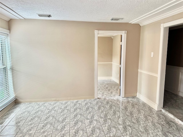 empty room featuring baseboards, visible vents, and a textured ceiling