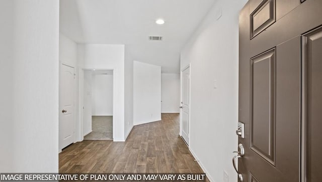 hallway featuring baseboards, visible vents, wood finished floors, and recessed lighting