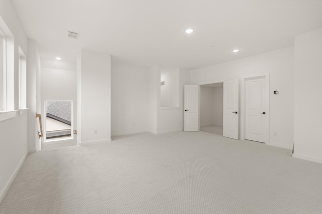 spare room with light carpet, baseboards, visible vents, and recessed lighting