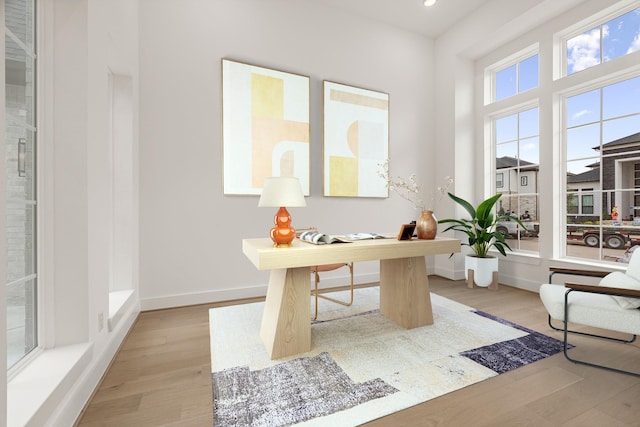 home office featuring light wood finished floors, recessed lighting, and baseboards