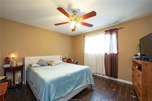 bedroom with a ceiling fan, wood finish floors, and baseboards