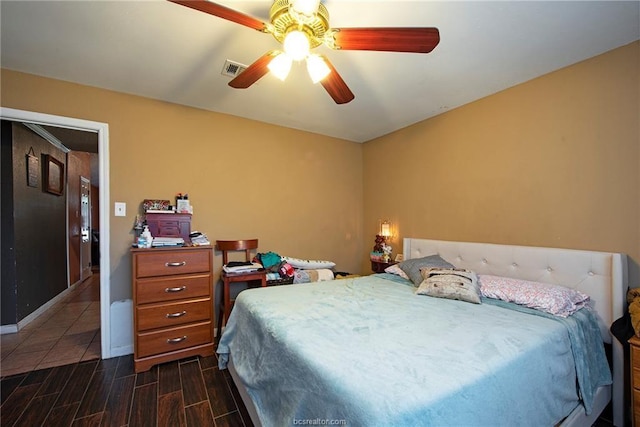 bedroom with visible vents, dark wood finished floors, baseboards, and ceiling fan