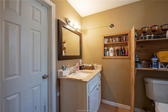 half bathroom featuring baseboards, vanity, and toilet