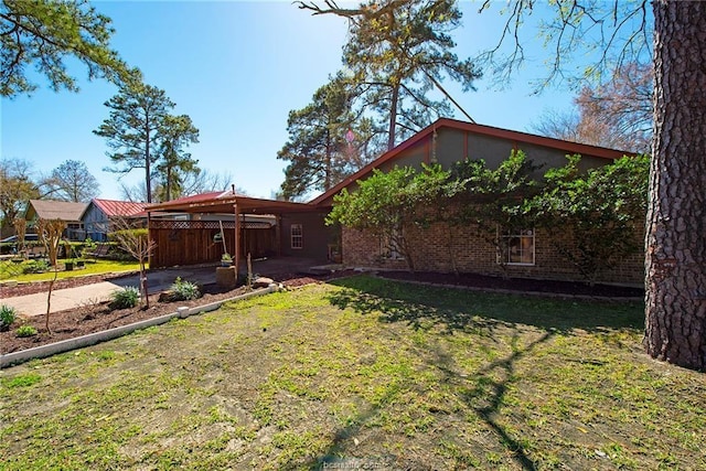 exterior space with driveway, brick siding, and a front lawn