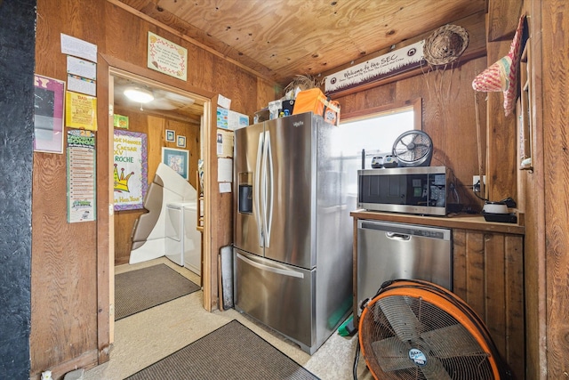 kitchen featuring wood ceiling, wooden walls, stainless steel appliances, and washing machine and clothes dryer