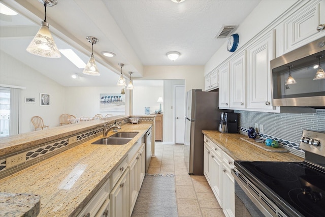 kitchen featuring stainless steel appliances, a sink, visible vents, light stone countertops, and tasteful backsplash