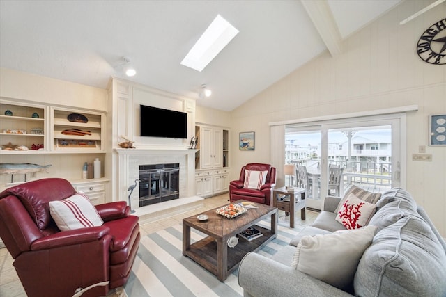 living area featuring a large fireplace, vaulted ceiling with skylight, and light tile patterned floors