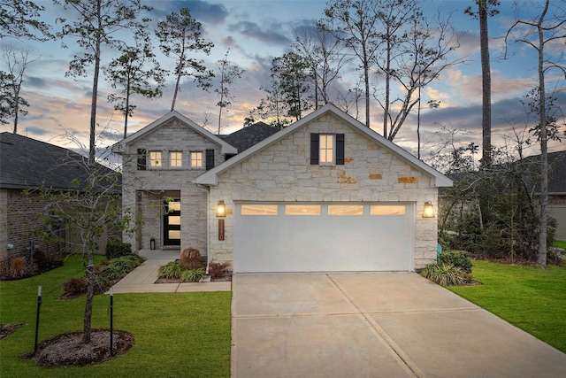 view of front of house featuring driveway, an attached garage, and a yard