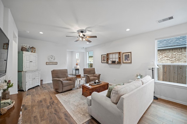 living area with recessed lighting, visible vents, a ceiling fan, wood finished floors, and baseboards