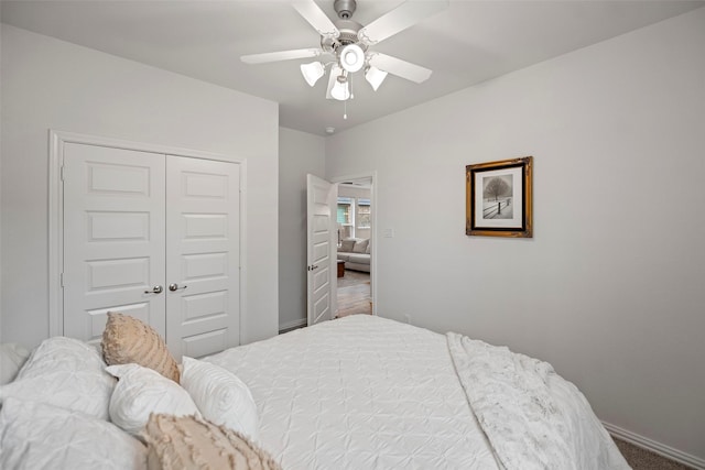 bedroom with ceiling fan, a closet, and baseboards