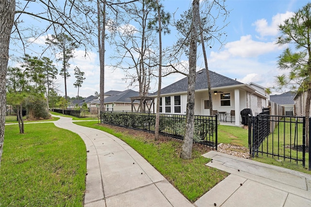 view of front of home with roof with shingles, a fenced front yard, and a front yard