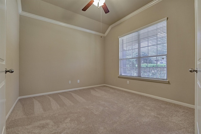 carpeted spare room featuring ornamental molding, vaulted ceiling, baseboards, and ceiling fan