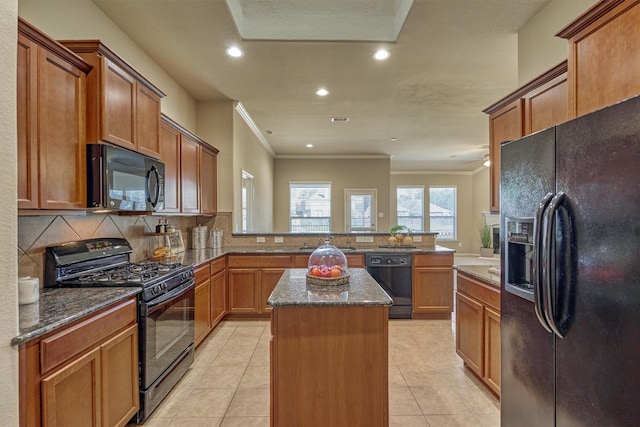 kitchen featuring light tile patterned floors, a peninsula, decorative backsplash, a center island, and black appliances