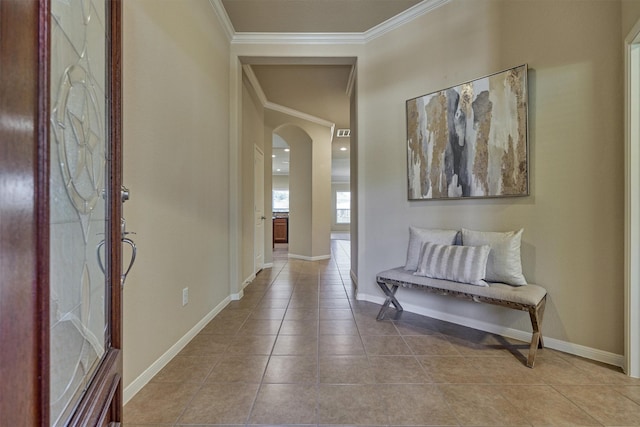 hallway with ornamental molding, arched walkways, baseboards, and tile patterned floors