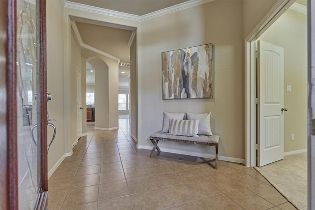 hallway with baseboards, arched walkways, crown molding, and tile patterned floors