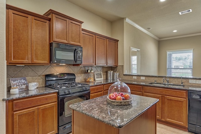 kitchen featuring black appliances, visible vents, decorative backsplash, and a sink