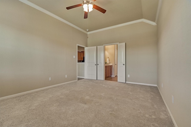 unfurnished bedroom with ensuite bathroom, carpet floors, a ceiling fan, baseboards, and crown molding