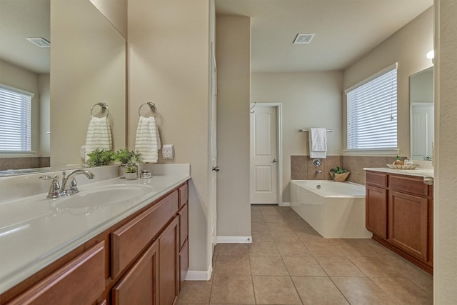 full bathroom featuring a garden tub, tile patterned flooring, visible vents, and a wealth of natural light