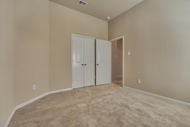 unfurnished bedroom with a closet, baseboards, visible vents, and carpet flooring