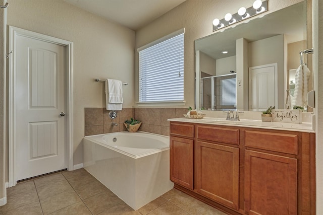 bathroom with a garden tub, a stall shower, tile patterned flooring, and vanity