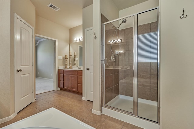 full bath featuring tile patterned flooring, vanity, visible vents, baseboards, and a shower stall