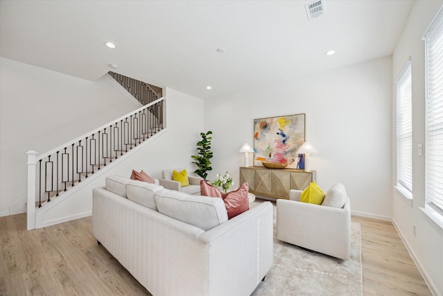 living area featuring light wood finished floors, stairway, visible vents, and recessed lighting