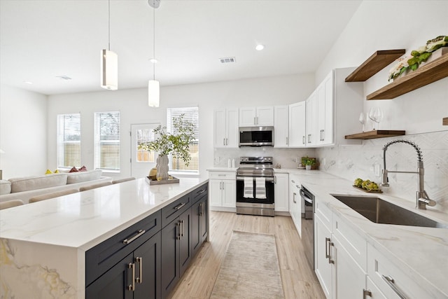 kitchen featuring a sink, stainless steel appliances, open shelves, and white cabinets