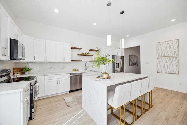 kitchen featuring stainless steel appliances, a sink, backsplash, a center island, and open shelves