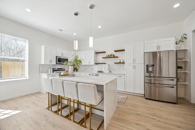 kitchen featuring open shelves, stainless steel appliances, light wood-style flooring, decorative backsplash, and white cabinetry