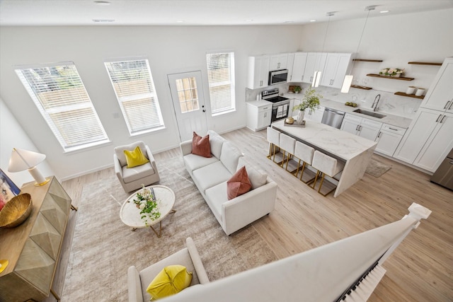 living room with light wood-type flooring, baseboards, and recessed lighting