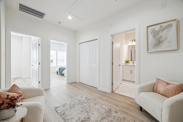 sitting room with baseboards, light wood-style flooring, visible vents, and recessed lighting