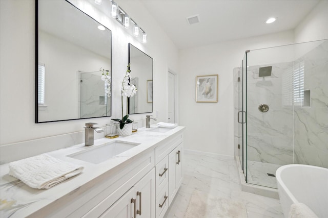 full bath with a freestanding bath, marble finish floor, a sink, and visible vents