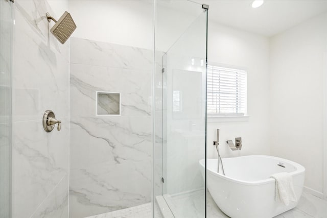 full bath featuring recessed lighting, a freestanding bath, and a marble finish shower