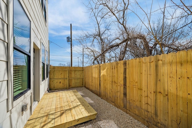 wooden terrace with a fenced backyard