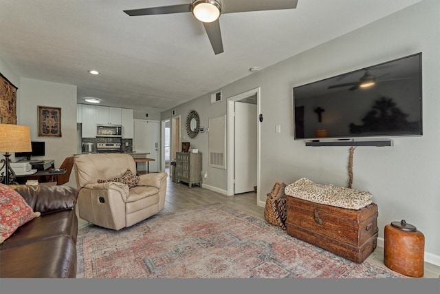 living area with light wood-style flooring, visible vents, and baseboards