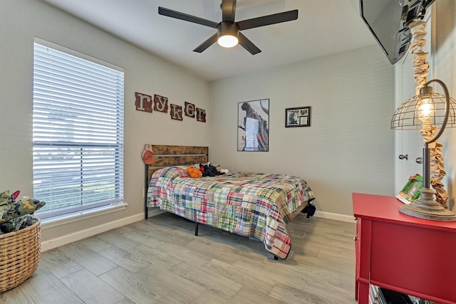 bedroom with a ceiling fan, baseboards, and wood finished floors