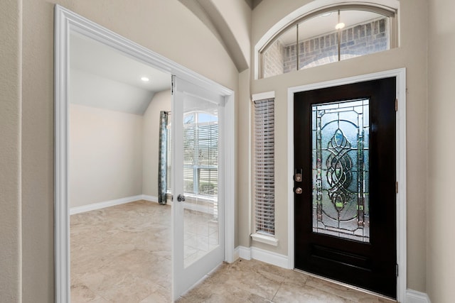 entrance foyer with lofted ceiling, french doors, and baseboards