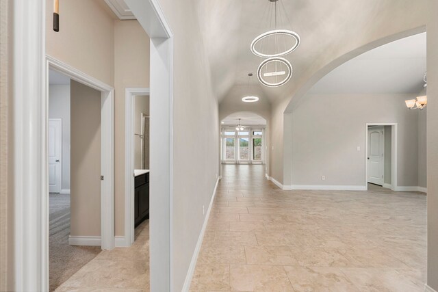 5615 Alexan Crest Dr, Fulshear, TX 77441 - corridor with a chandelier, arched walkways, baseboards, and lofted ceiling