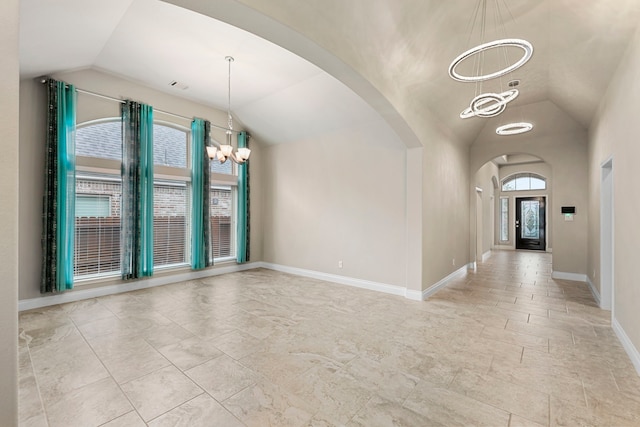 interior space with baseboards, arched walkways, vaulted ceiling, and a notable chandelier