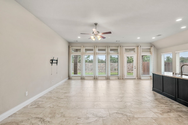 unfurnished living room with ceiling fan, recessed lighting, a sink, baseboards, and vaulted ceiling