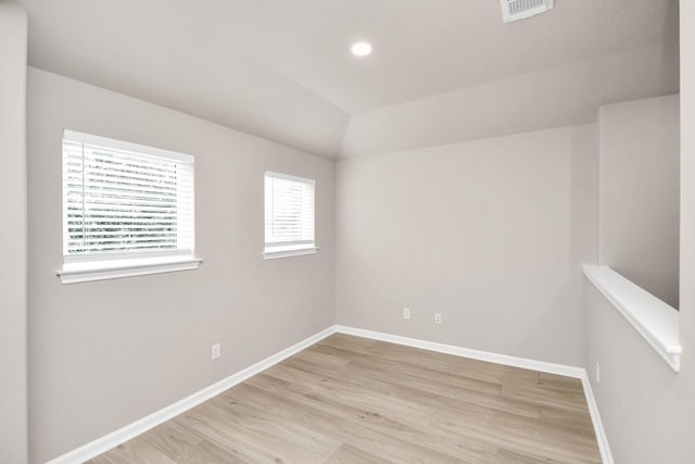 empty room featuring lofted ceiling, recessed lighting, visible vents, baseboards, and light wood-type flooring