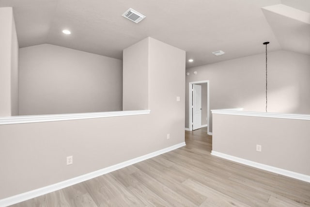 empty room with baseboards, visible vents, wood finished floors, vaulted ceiling, and recessed lighting