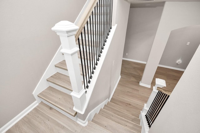 staircase featuring baseboards and wood finished floors