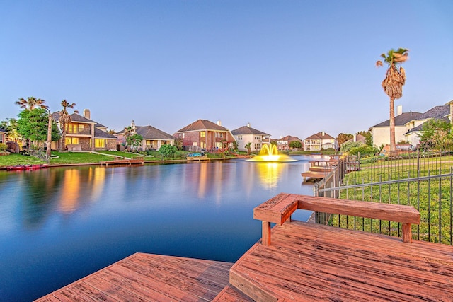 view of dock with a residential view and a water view