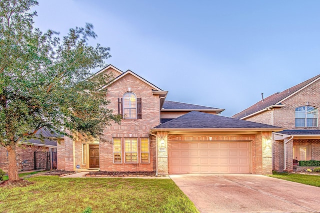 traditional-style house with a garage, driveway, brick siding, and a front yard