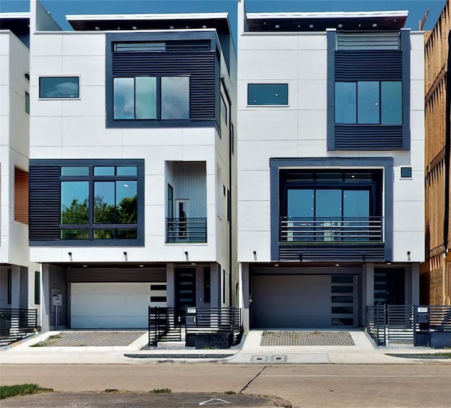 contemporary home with decorative driveway, an attached garage, and stucco siding