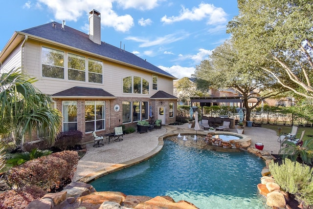 view of pool with a pool with connected hot tub, a patio area, and a fenced backyard